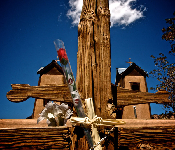 Wooden cross with two church towers in background